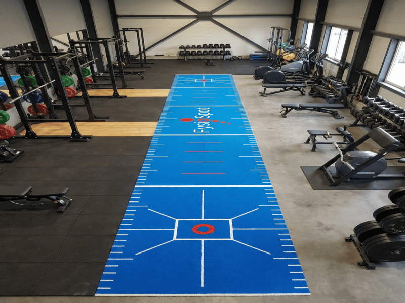 application de l'adhésif sur les bords du sol de la salle de sport